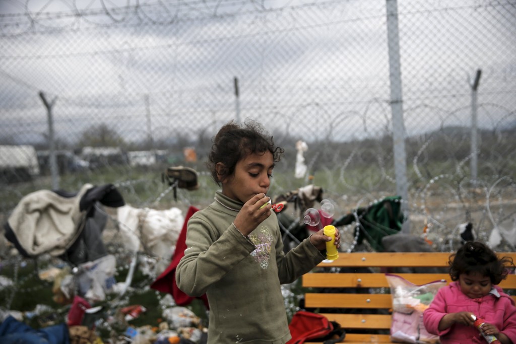 Refugiada Siria juega con burbujas cerca de la fronter a de Grecia con Macedonia