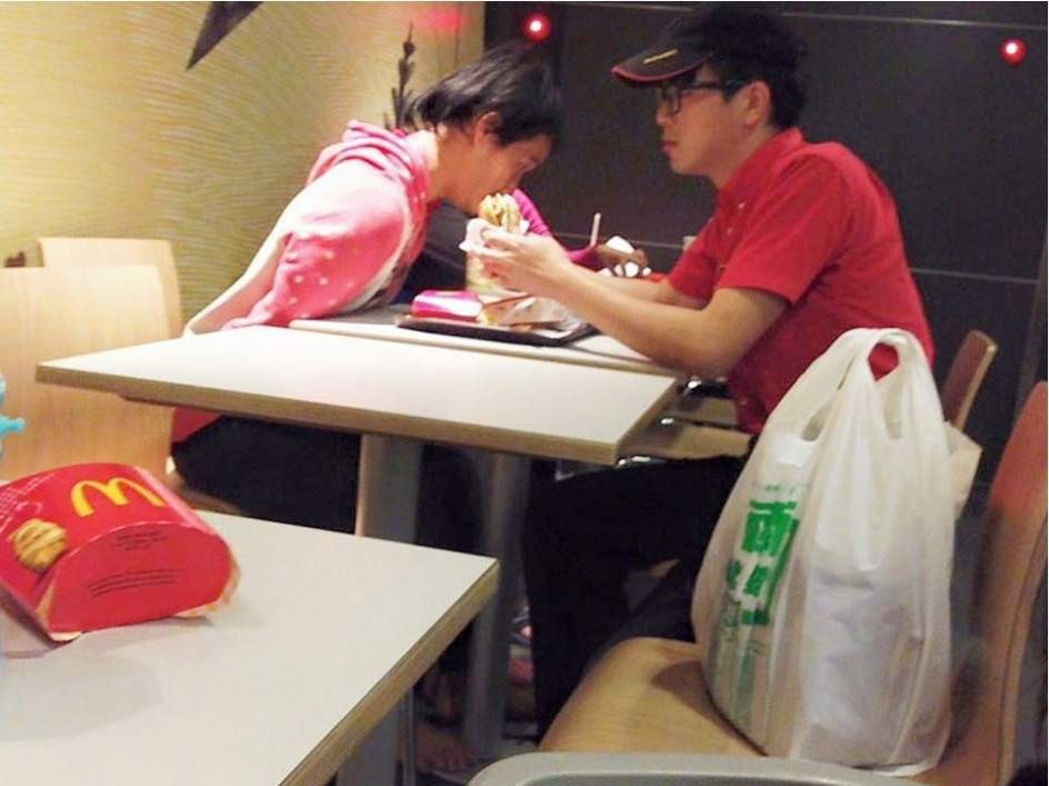 Empleado de McDonald's dando de comer a persona con discapacidad