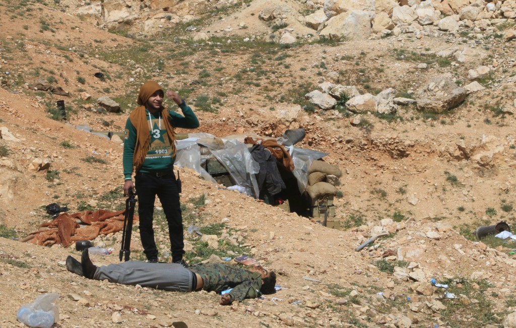 Soldado rebelde sirio sobre el cadáver de un soldado fiel a Bashar al-Assad