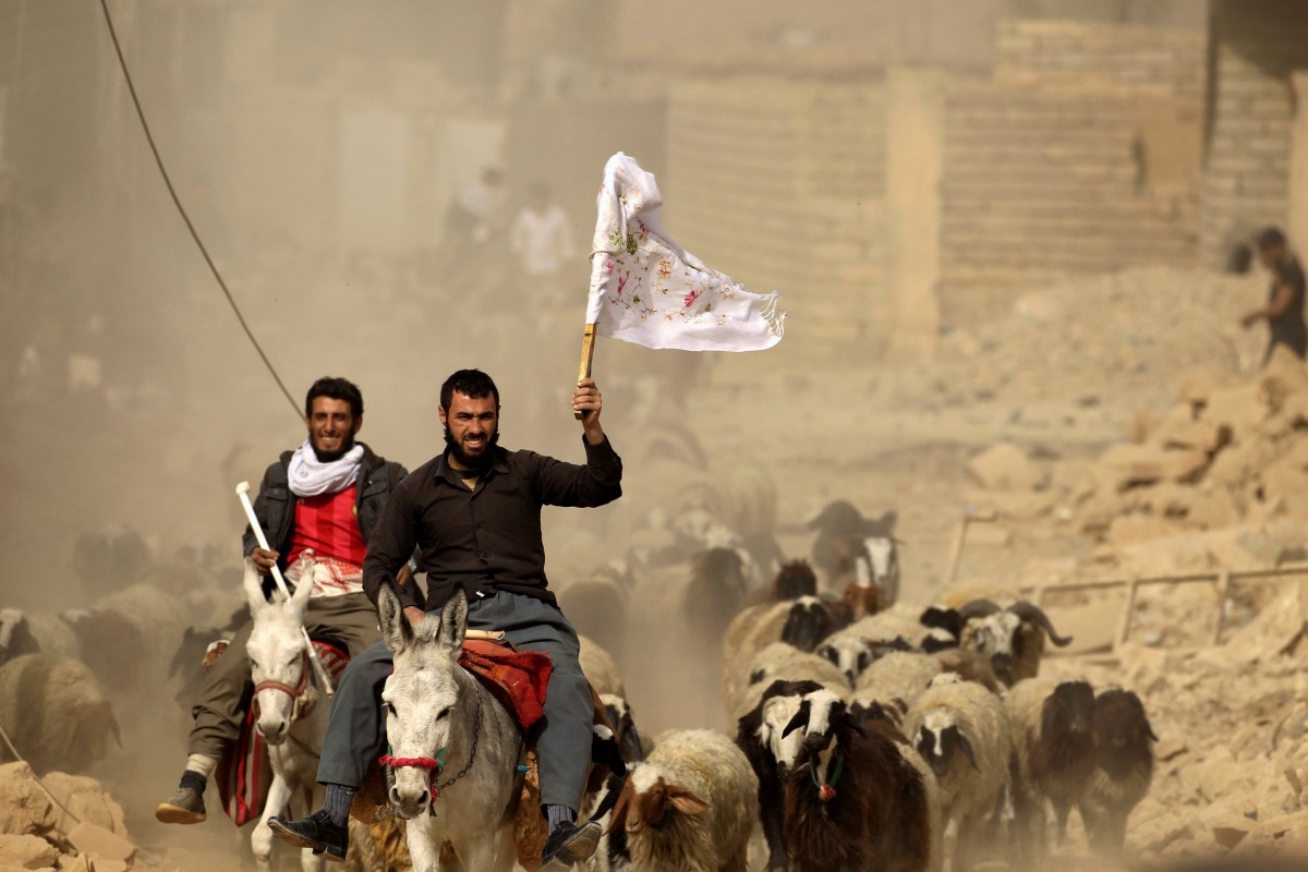 Un hombre porta una bandera blanca mientas se aproxima a uno de los puntos de control de la coalición al este de Mosul | FOTO: REUTERS/Zohra Bensemra
