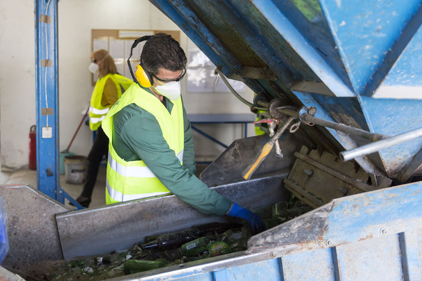 Trabajador de una planta de tratamiento de residuos de cristal para su reciclado | DA