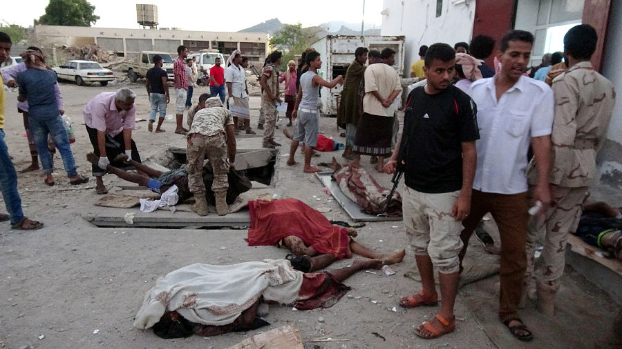 Soldados y civiles junto a los cuerpos sin vida que deja el atentado suicida en la base militar a base militar de Yemen | REUTERS/Fawaz Salman