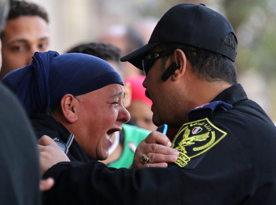 Una víctima de la explosión en la Catedral de San Marcos grita de dolor frente a un agente de seguridad en El Cairo | REUTERS/Mohamed Abd El Ghany