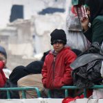Unos niños junto a otras personas en un camión a la espera de ser evacuados del sector rebelde de Alepo | REUTERS/Abdalrhman Ismail
