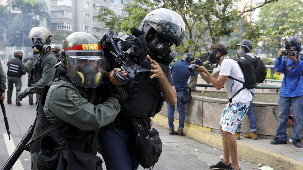 Un cámara es detenido por la Policía durante una manifestación en Venezuela. REUTERS/Carlos Garcia