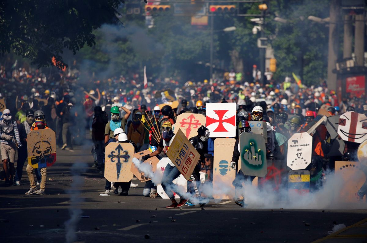 Manifestantes hacen frente a las cargas policiales en Caracas | REUTERS