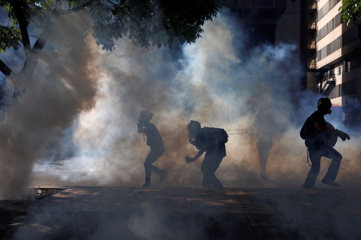 Manifestantes hacen frente a las cargas policiales en Caracas | REUTERS