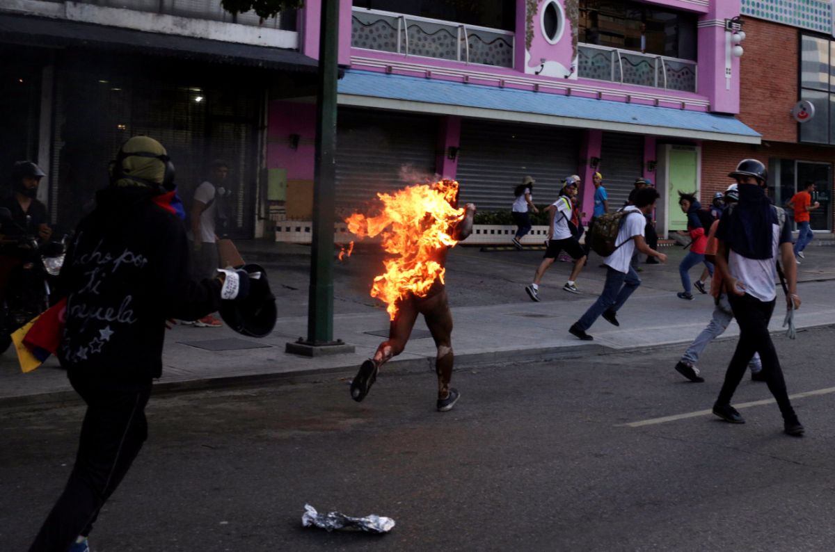 Un hombre corre envuelto en llamas tras ser prendido fuego por una multitud acusado, supuestamente, de ser chavista durante una manifestación en Caracas |  REUTERS/Marco Bello