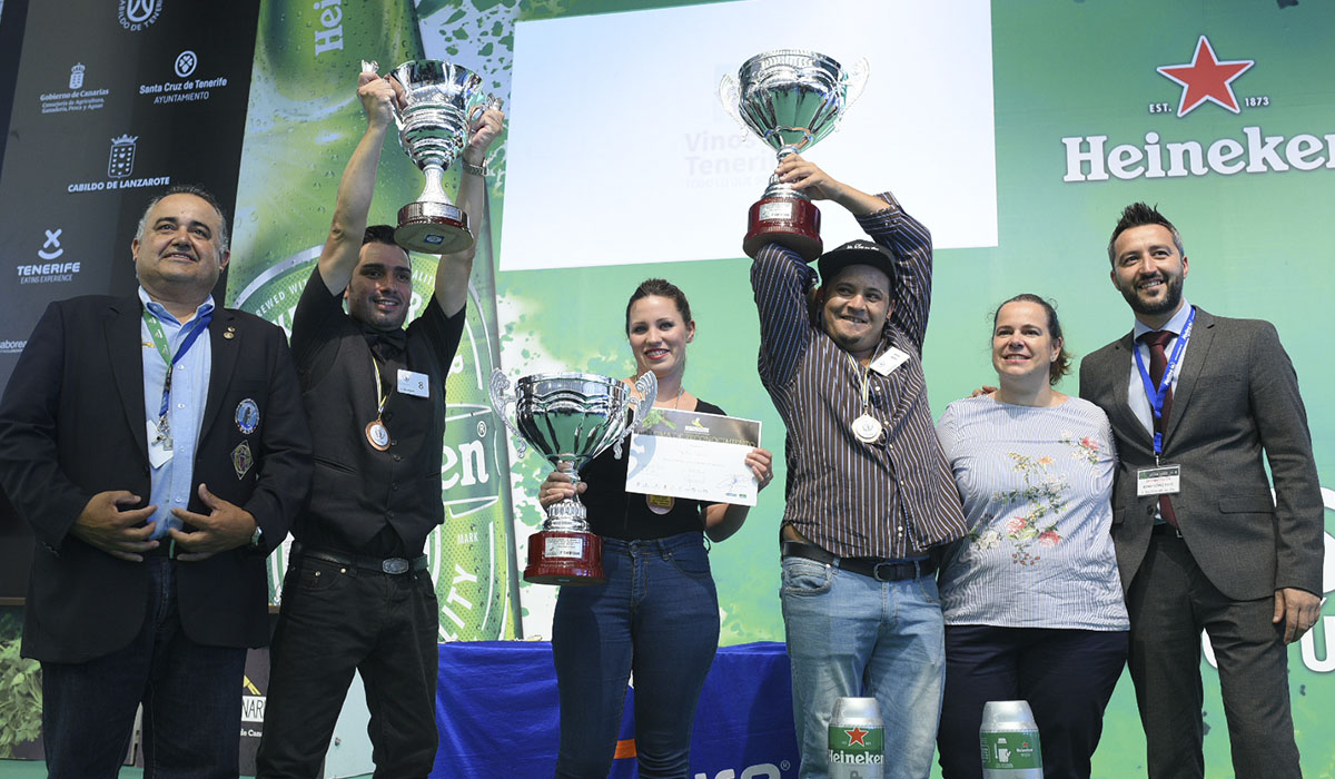 Óscar Gómez, Delia García y Josué Rodríguez alzan sus trofeos en el escenario Heineken. DA