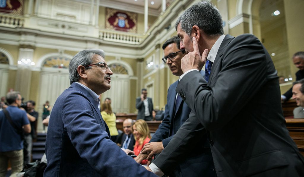 Román Rodríguez habla con el jefe del Gobierno, Fernando Clavijo, en el Parlamento, junto al vicepresidente, Pablo Rodríguez. Andrés Gutiérrez