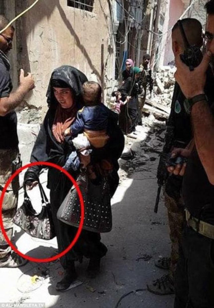 Una mujer suicida porta a su hijo en brazos mientras lleva en su bolso un artefacto explosivo que con posterioridad detonó en Mosul | FOTO:  Al-Mawsleya TV