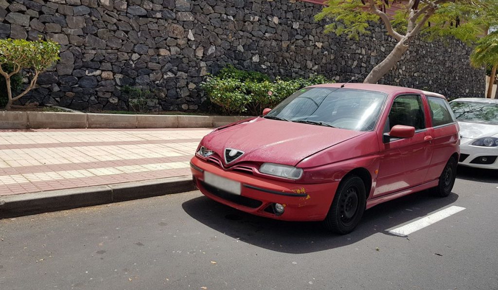 Imagen del vehículo Alfa Romeo rojo modelo 145 con llantas negras. DA