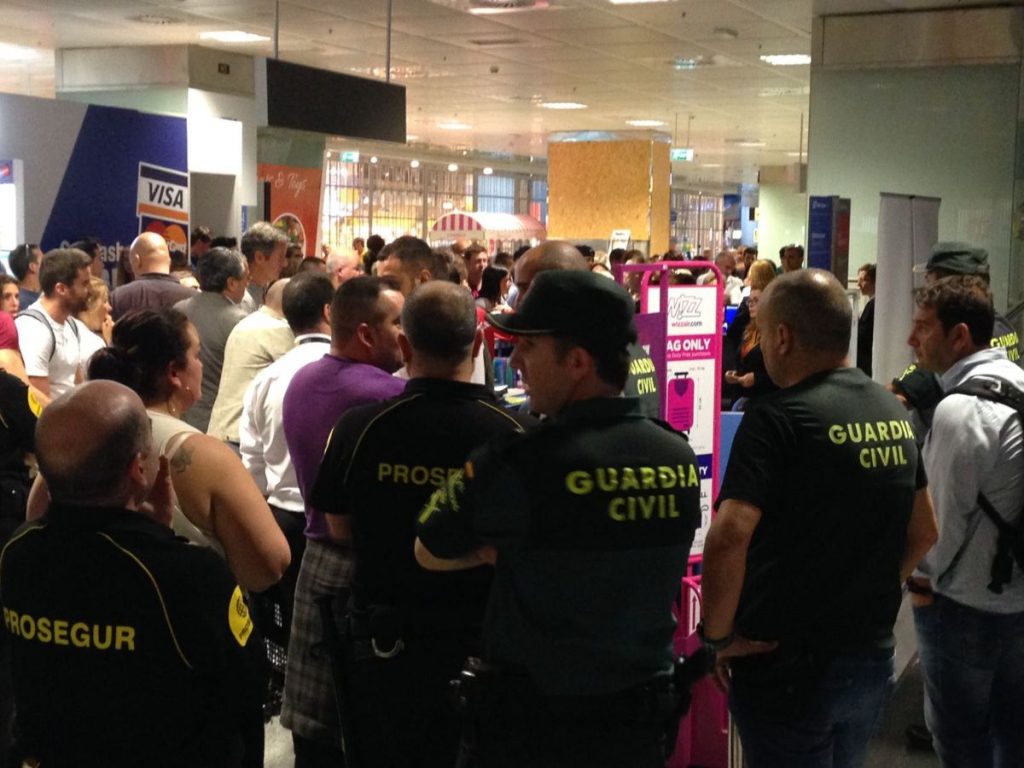 Guardia Civil y vigilantes de seguridad, junto a los irritados pasajeros, ayer en el Reina Sofía. DA