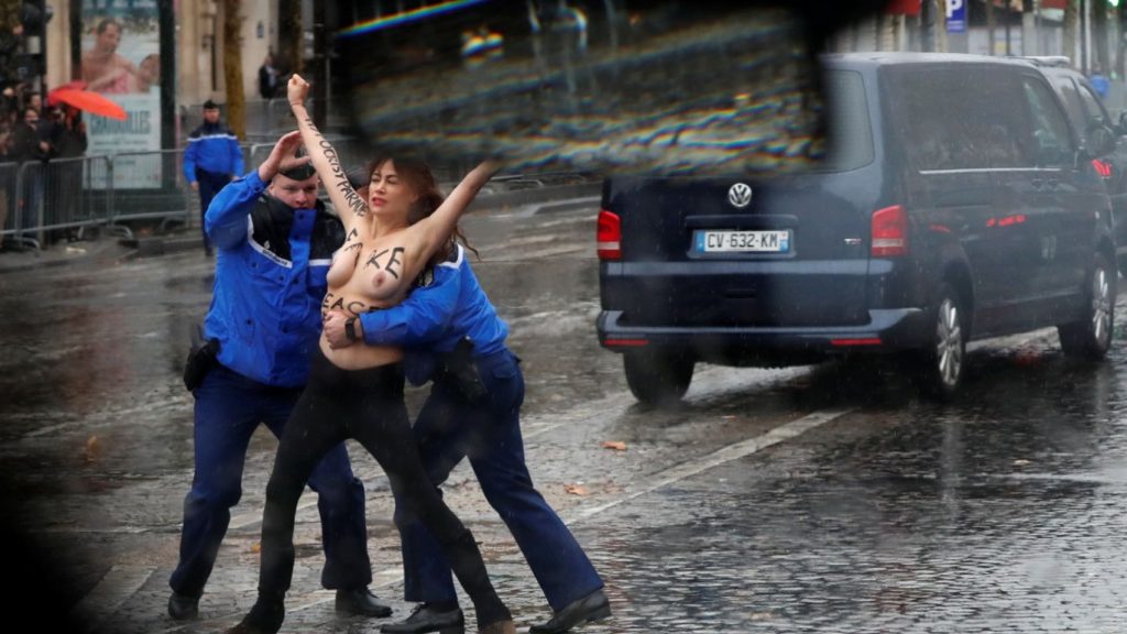 Una activista de Femen, detenida antes de alcanzar la caravana de Trump en la ceremonia del Armisticio. / EE