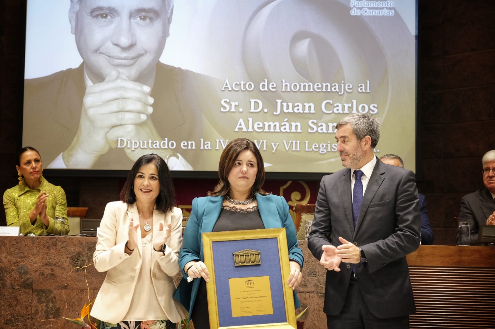 Arriba, la hija del homenajeado, Patricia Alemán, recibe un recordatorio en un acto multitudinario al que no faltaron algunos de los expresidentes autonómicos. S.M.