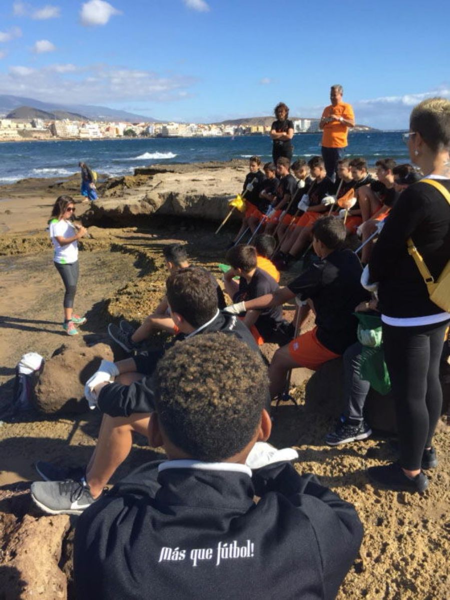 A la izquierda, varios jugadores del AS Tenerife en el transcurso de un partido; en la otra imagen, la plantilla  asiste a una charla sobre los efectos de los microplásticos durante una campaña de limpieza en la costa de Granadilla. DA