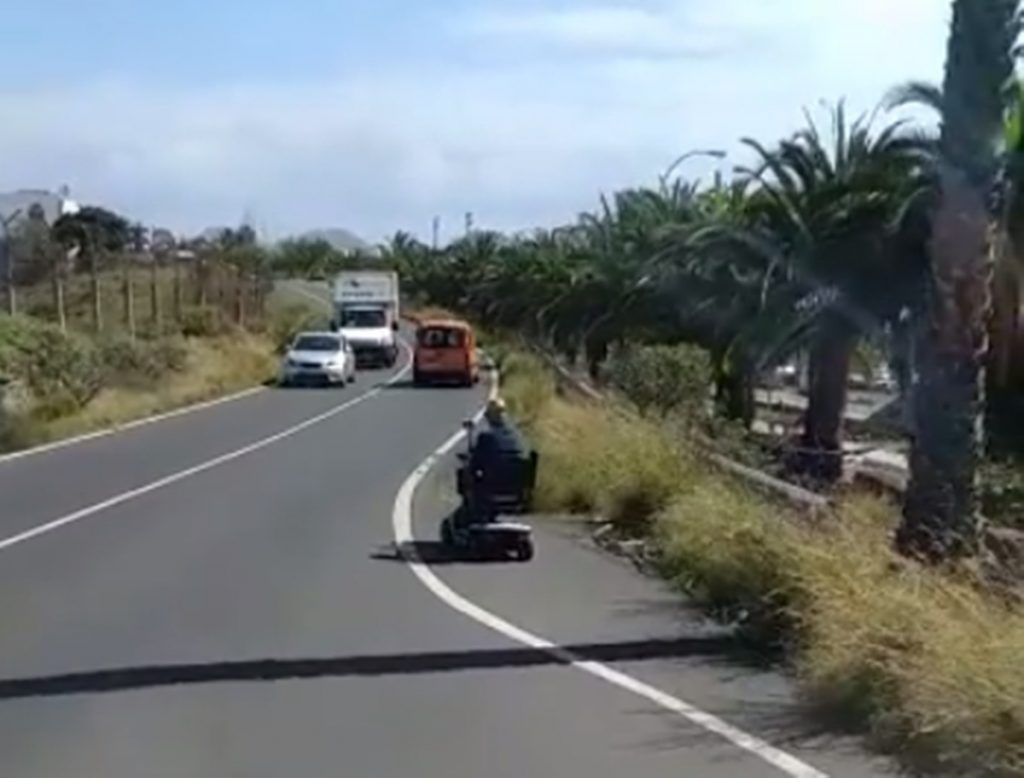 Un hombre circula en silla de ruedas por la carretera. Facebook de Canarias