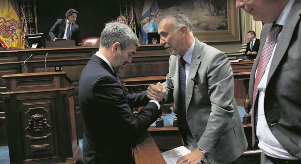 Fernando Clavijo (CC) y Ángel Víctor Torres (PSOE) se saludan ayer en el Parlamento regional al final de la primera sesión para la investidura del nuevo presidente. Foto: Fran Pallero