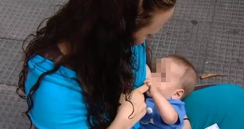 Una mujer da el pecho a su bebé.