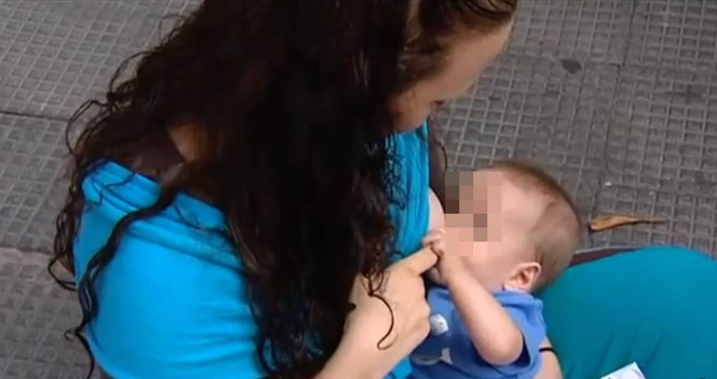 Una mujer da el pecho a su bebé.