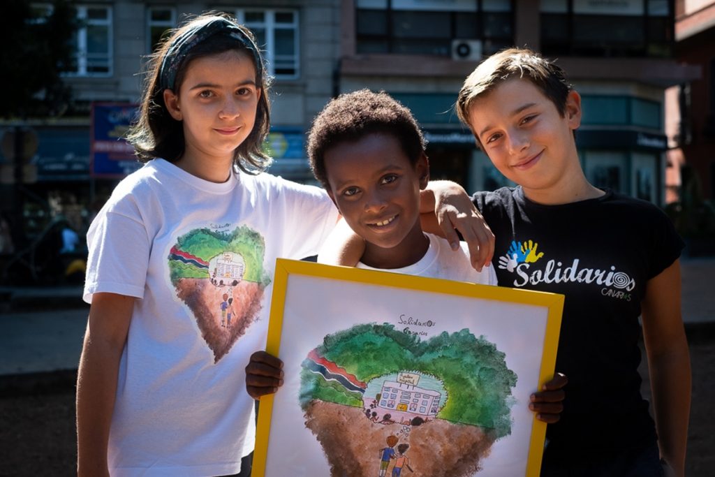 Adriana, Ayalew y Airam posan con el dibujo con el que Solidarios Canarios recauda dinero para su nuevo proyecto en tierras gambianas. Fran Pallero