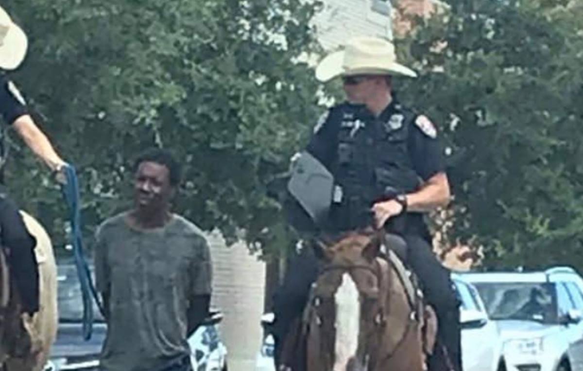 dos policías a caballo llevan esposado y amarrado con una cuerda a un hombre negro. Twitter