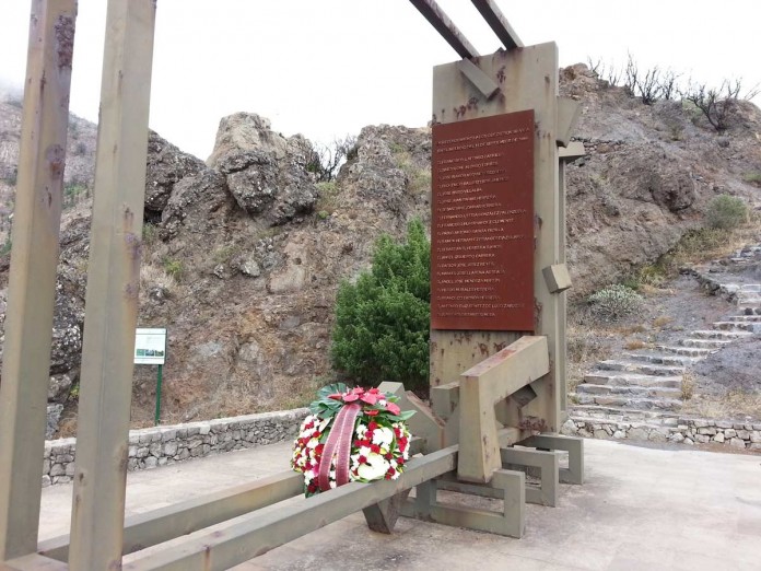 El monumento, que recuerda a los fallecidos, con una corona de flores. DA