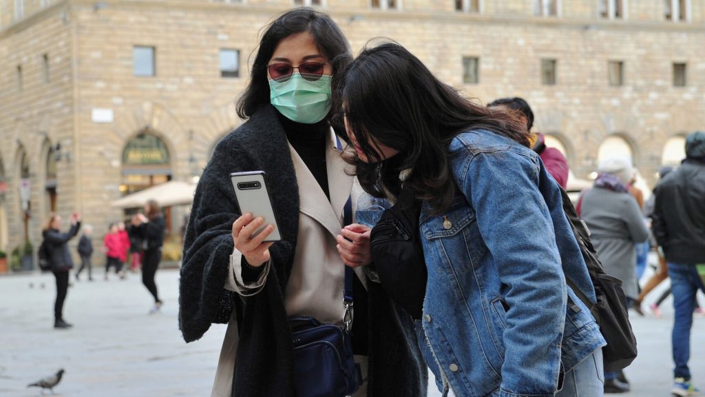 Dos turistas con mascarillas en Italia. El Español