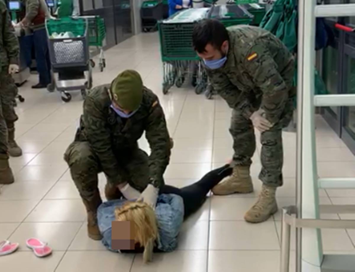 Dos militares detienen a una mujer en el súper. DA
