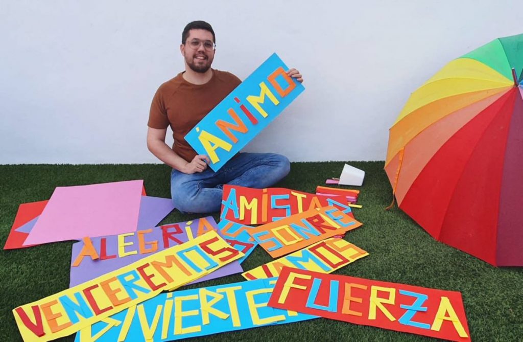 Samuel Pérez junto a varios carteles que muestra desde su terraza para motivar al vecindario;. DA
