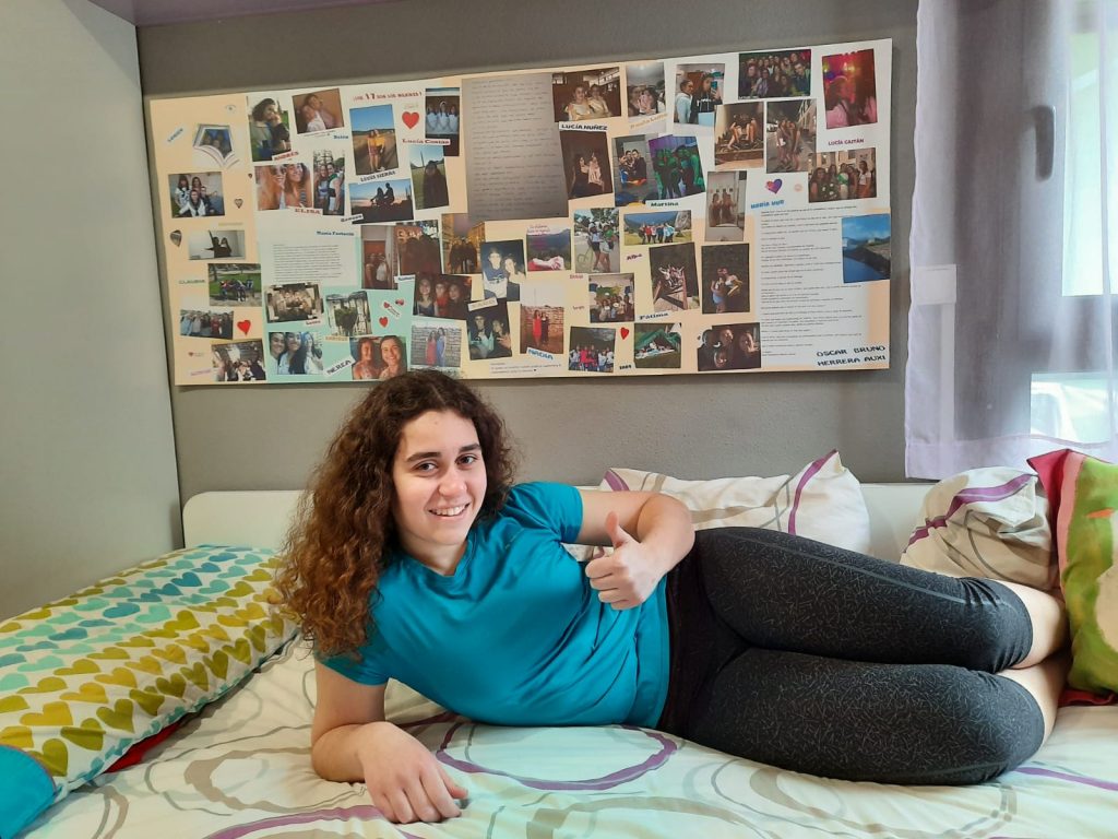 Ibón Cejalvo Aljama junto con la sorpresa que le preparó su madre, un enorme mural con fotos y mensajes de sus familiares, amigos y también de Auxi.