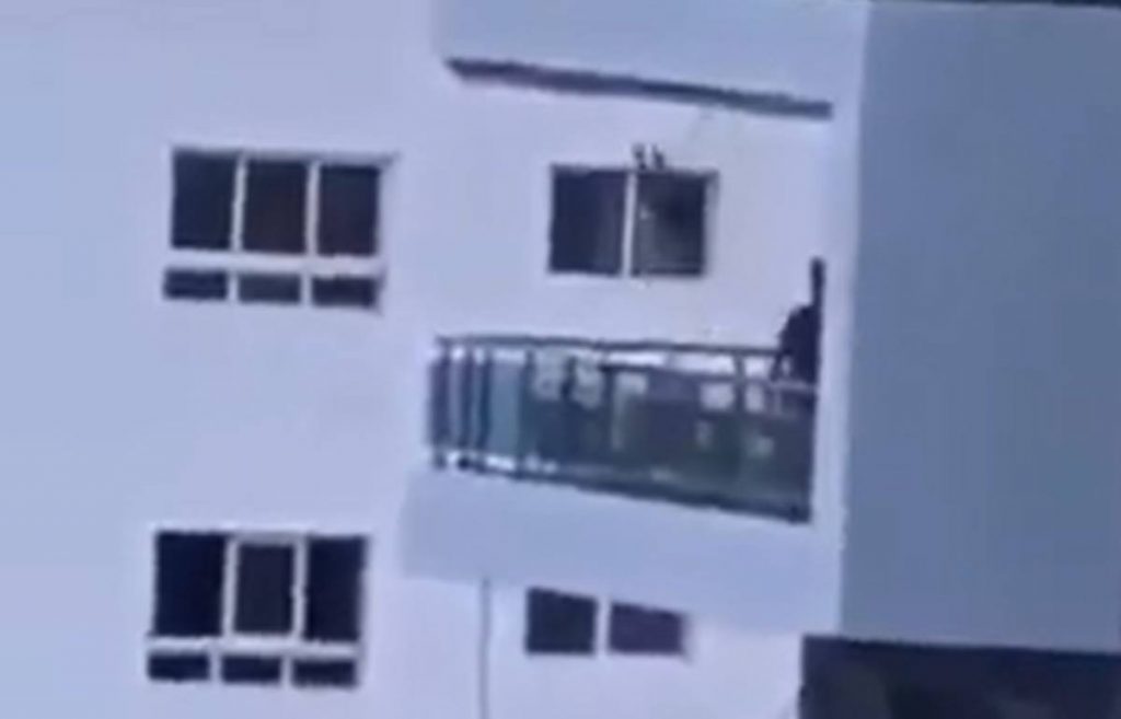 Un padre columpia a su hija en un balcón. Twitter (@JonaPCruz)