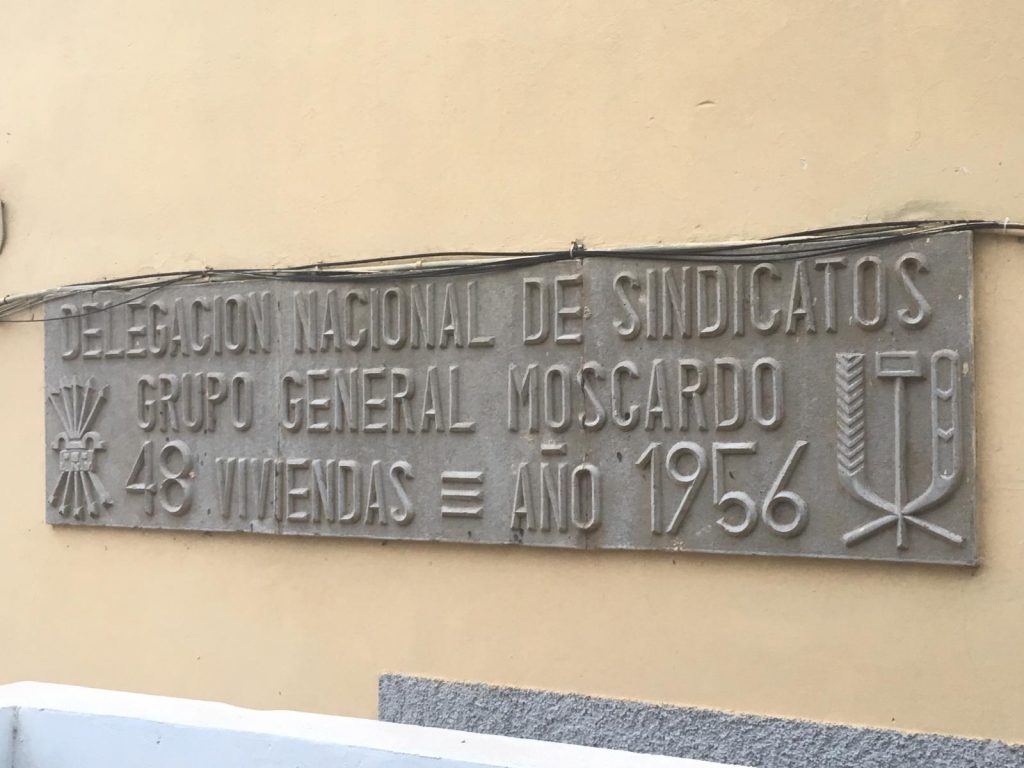 Placa de la barriada General Moscardó, con escudos falangistas. DA