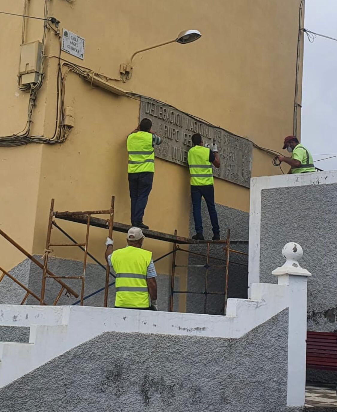 Cuatro operarios procedieron ayer a la retirada de las letras, símbolos y números de la placa ubicada en la barriada General Moscardó. DA