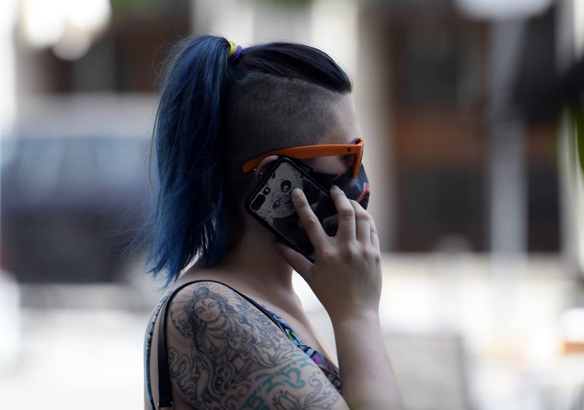 Una mujer con mascarilla habla por teléfono el día en el que entra en vigor en la Comunidad de Madrid