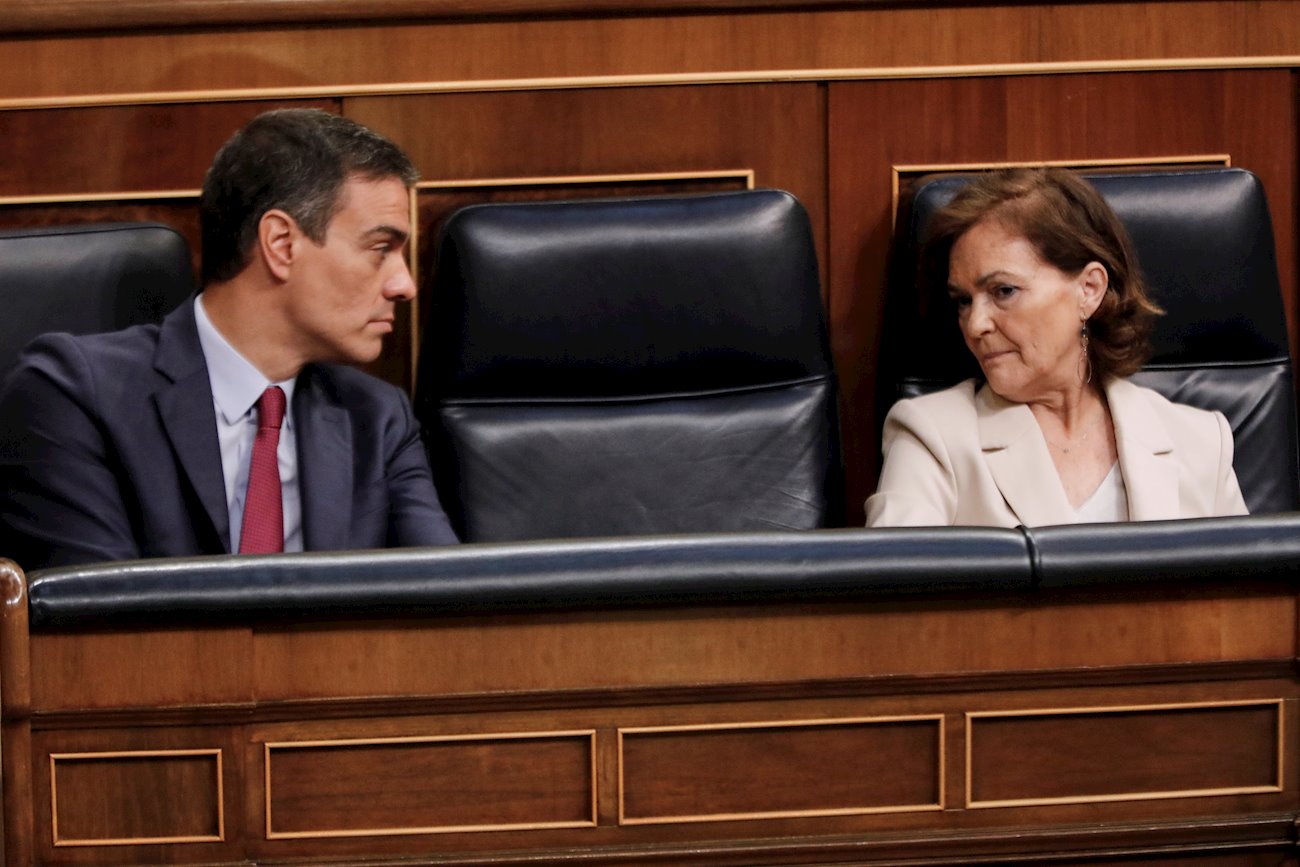 La vicepresidenta primera, Carmen Calvo, habla con el presidente del Gobierno, Pedro Sánchez, durante una sesión plenaria en el Pleno del Congreso