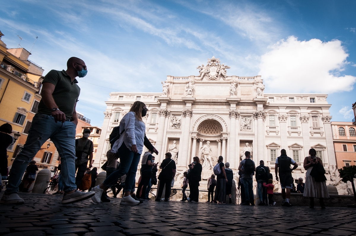 Personas con mascarilla delante de la Fontana de Trevi en Roma