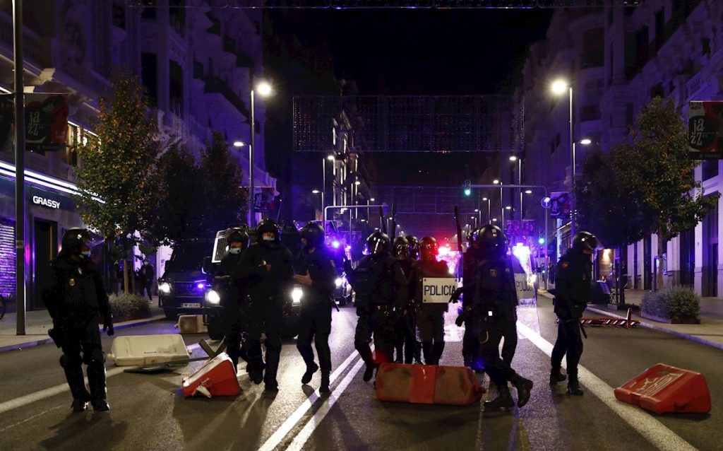 Miembros de la Policía Nacional recorren la Gran Via de Madrid ante las protestas convocadas esta noche por las medidas tomadas tras el aumento de contagios por coronavirus. EFE / Javier López.