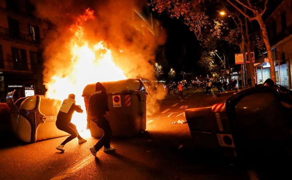 Los disturbios, como el de la imagen en Barcelona, promovidos desde las redes sociales, se produjeron en varias ciudades españolas, imitando los choques violentos y las barricadas en Italia.