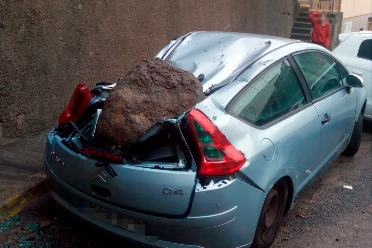 Una roca de grandes dimensiones cae sobre un coche en Las Palmas de Gran Canaria debido a la lluvia
