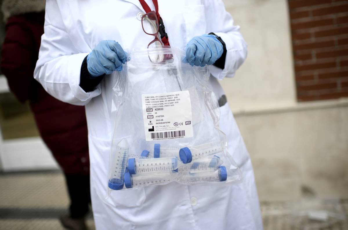 Un sanitario con tubos de ensayo durante la realización de tests de RT-PCR. Imagen de archivo