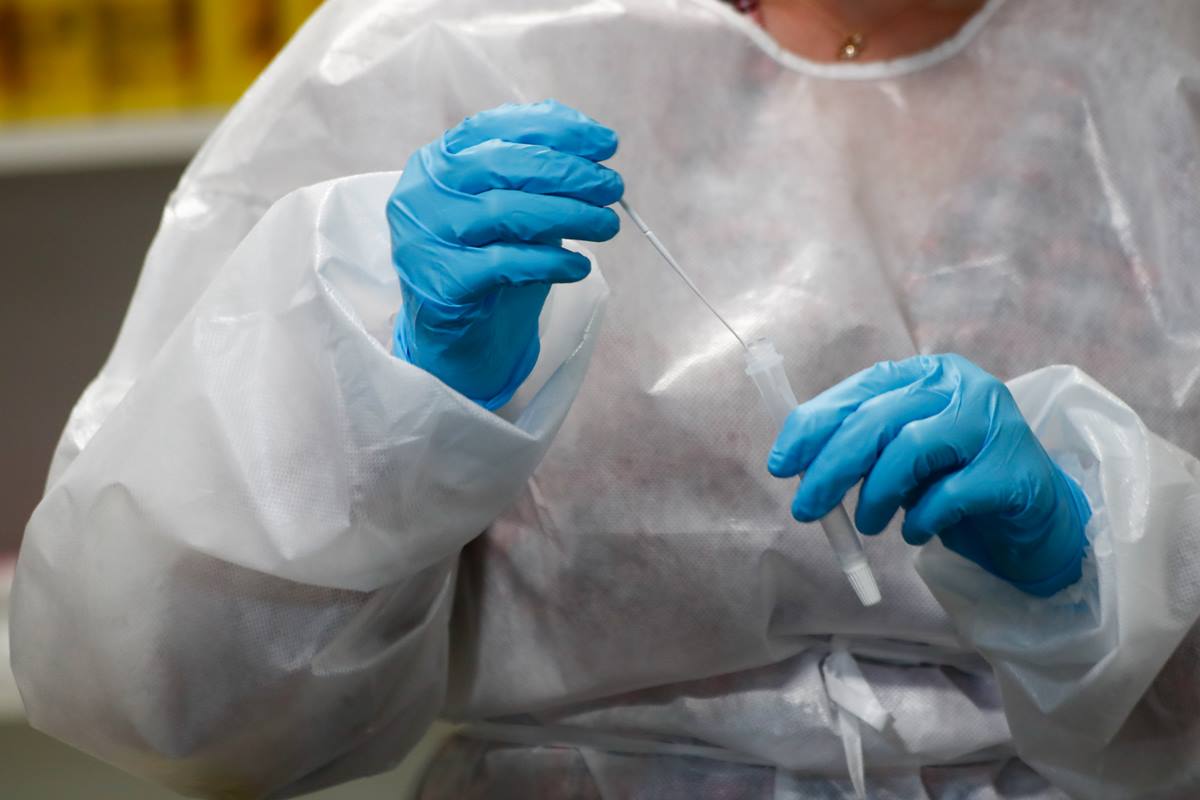 Imagen de recurso de una trabajadora sanitaria sostiene un test de antígenos. EP