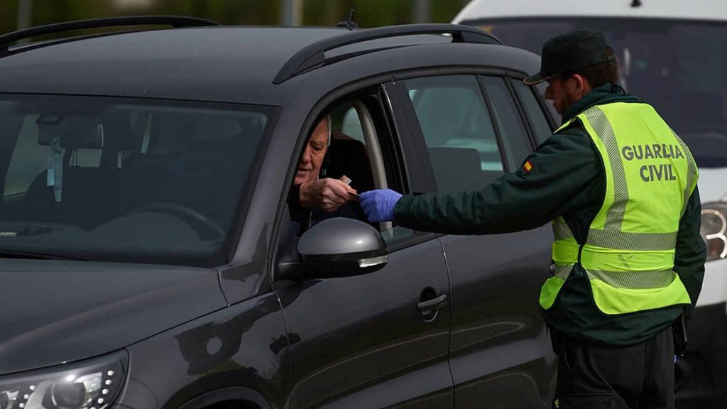 Un agente de la Guardia Civil, solicitando a un conductor su permiso de conducir.