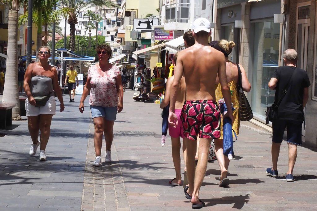 Un joven camina sin camiseta por la calle en Los Cristianos. SERGIO MÉNDEZ