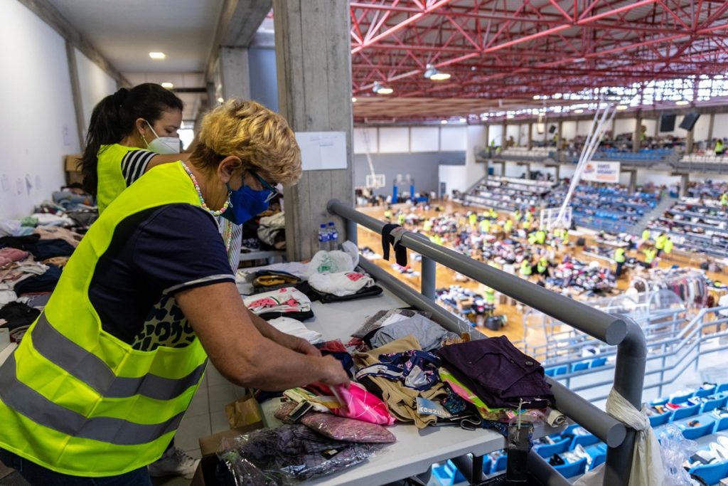 Varias personas colaboran y apilan ropa y objetos en el Polideportivo Severo Rodríguez de Los Llanos de Aridane. Kike Rincón / EP