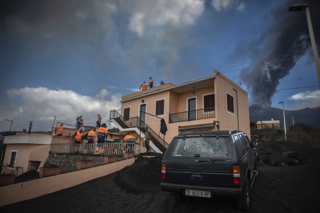 Voluntarios retiran cenizas de las casas próximas al volcán de La Palma