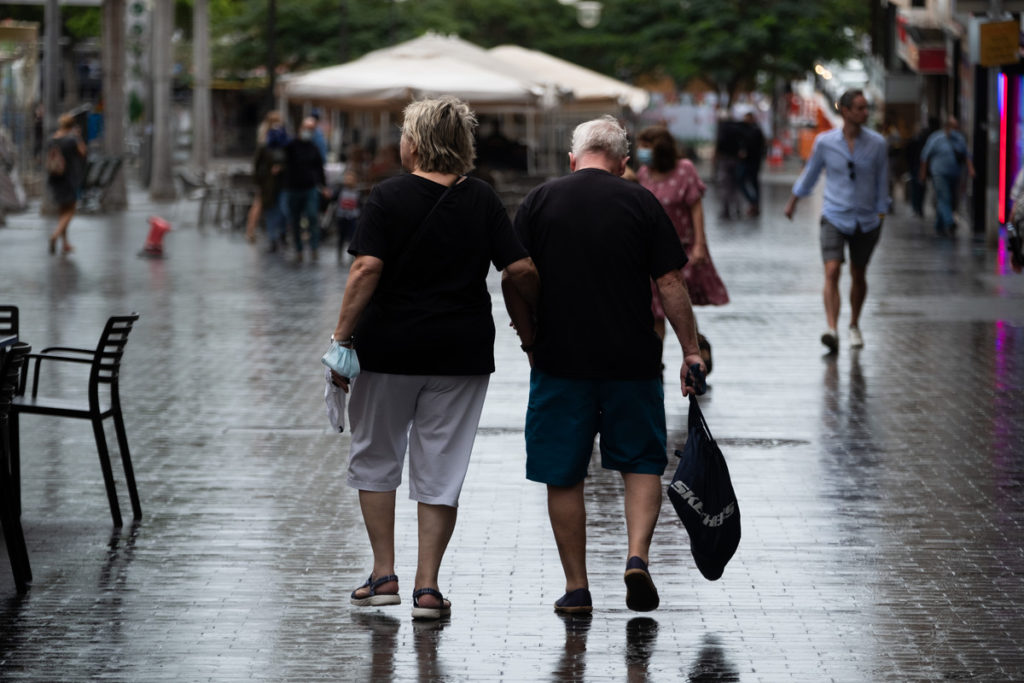 Dos personas caminan por la Plaza España en Santa Cruz en un día de frío y lluvia. FRAN PALLERO