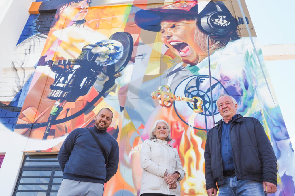 Eliezer Marrero (i), Susana Caloca y José Barco Cabello, directivos de la Asociación Giro, ante el mural exterior del colegio de El Tablero. Sergio Méndez