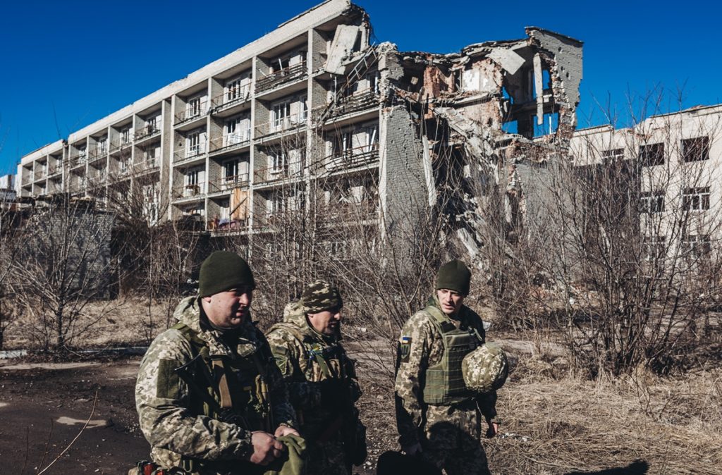 Varios soldados ucranianos caminan frente a un edificio derruido en un pueblo cercano a la línea de contacto. EP