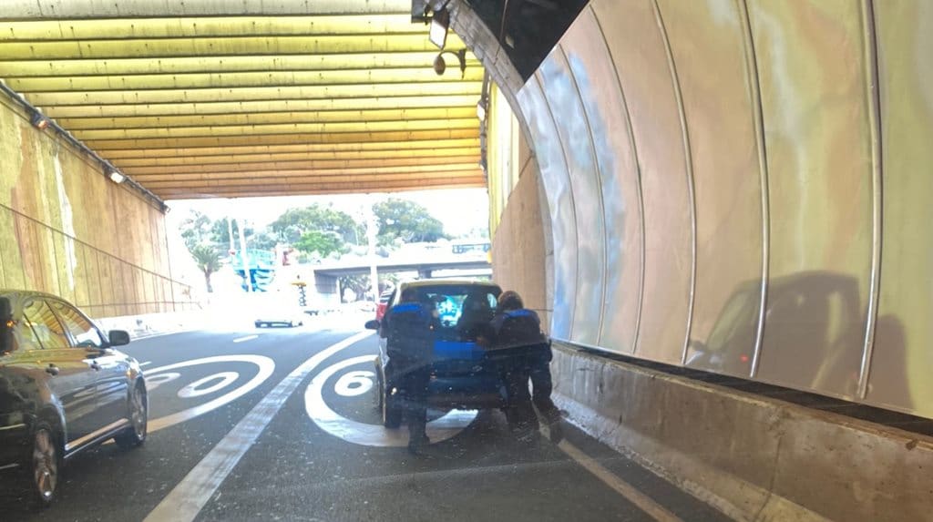 Policías locales empujan un coche para sacarlo de un túnel